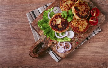 Fried chicken cutlets, minced chicken, with vegetables, on a cutting board, with vegetable salad,