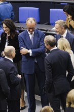 Olaf Scholz (SPD), Federal Chancellor, greets Friedrich Merz, CDU, and Christian Lindner in plenary