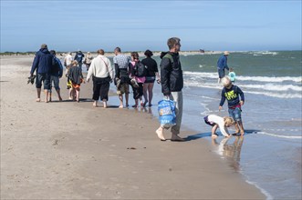 Ttourists walking at the northern tip of Denmark where the Baltic Sea and North Sea meet at Skagen