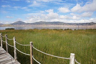 Lake Titicaca, in front reeds and a wooden footbridge, behind Puno, Puno province, Peru, South