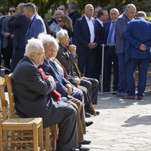 Survivors of the massacre of 3 June 1941, Elderly men in suits sit on chairs at an outdoor