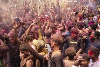 Revellers dancing in the beat of music as they celebrate Holi on a street, the Hindu spring