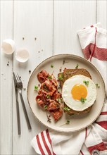 Breakfast, fried egg with bacon, micro-green, on a light background, no people, selective focus