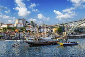 View of Porto city and Douro river with traditional boats with port wine barrels and sailing ship