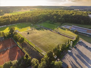 Aerial view of sports fields and buildings at dusk surrounded by nature, Gechingen, Black Forest,