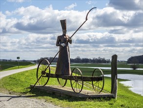 Sculpture on dike at River Elbe, Mödlich, ferryman bringing people to the world of death, Germany,