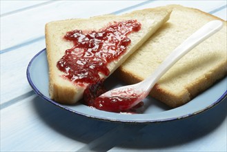 Toast with raspberry jam on a plate, breakfast