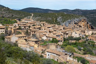 View of a medieval village with traditional stone houses nestled in a hilly landscape, Alquézar,