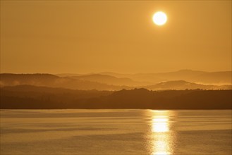 Atmospheric landscape scene at sunrise, landscape in twilight with soft fog, calm sea, Bergen,