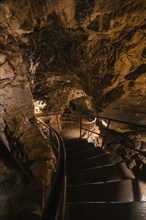 A spiral staircase in a dark cave leading into the depths, St. Beatus Caves, Switzerland, Europe