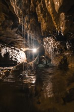 An illuminated cave room with dripping water and fascinating formations, St. Beatus Caves,