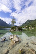 Hintersee near Ramsau with clear green water, surrounded by forests and mountains under a cloudy