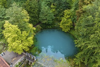 Blautopf Blaubeuren, source of the River Blau in a landscape with forest. Karst spring, geotope and