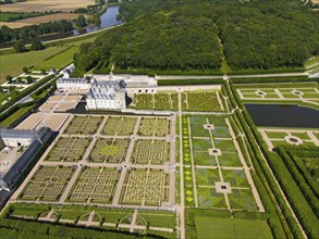 Aerial view of a castle with formal, geometric gardens consisting of labyrinths, ponds and