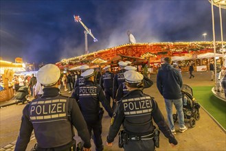 Police patrol at the Cannstatter Volksfest in the evening to ensure safety. It is one of the most