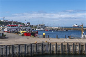 Inland harbour with sailing yachts and offshore supply ships, pier, passenger ship MS Maud of