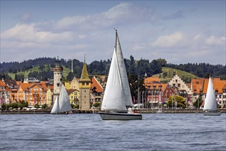 Harbour of Lindau, town view with lighthouse and man tower, sailing boat. Lindau, Lake Constance,