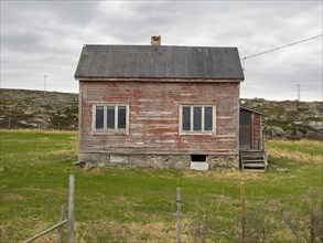 Derelict house on the shore of the Arctic Ocean, beside the town of Nesseby, May, Varangerfjord,