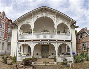 Old, splendidly decorated building with wooden ornaments under a cloudy sky, Rügen