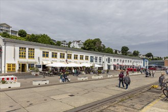 Lively harbour area with people, market stalls and buildings along the street, Rügen