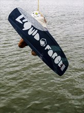 Young man with wakeboard at the jump start, water sports in the wakepark