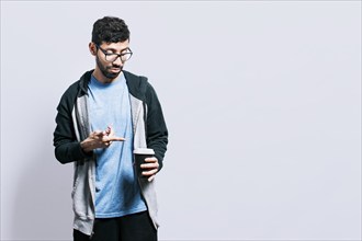 Person holding and pointing coffee on isolated background. Guy pointing disposable cup of coffee