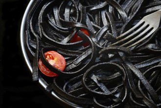 Black pasta coloured with squid ink on a plate, Taglioni al Nero di Seppia, Italy, Europe