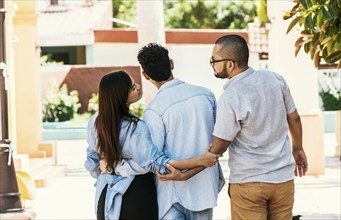 Woman holding hands with another man while walking with her boyfriend on the street. Love triangle