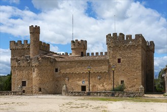 A medieval castle with high sandstone walls and towers against a cloudy sky, Castillo de la