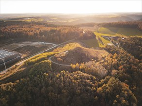 Autumn landscape with hills and forests from the air at sunset, Lindenrain industrial area,