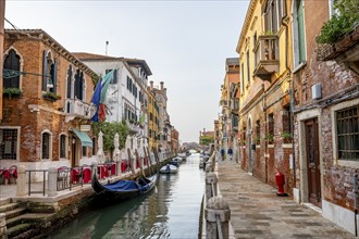 Venetian gondolas and colourful house facades on a small canal, Venice, Veneto, Italy, Europe