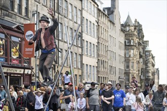 Street performers and spectators at a high-wire acrobatics performance, world's largest cultural