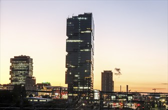 Sunset at the Modersohn Bridge, view of railway tracks, trains and the 140 metre high Amazon office