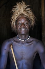 Young Himba man in his hut, Ohandungu, Kunene region, Kaokoveld, Namibia, Africa