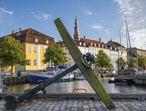 Old anchor, sailing boats, historic buildings and tower of Vor Frelsers Kirke or Church of the