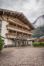 Rustic hotel in the Alps with wooden balcony and colourful floral decorations, Mayrhofen,