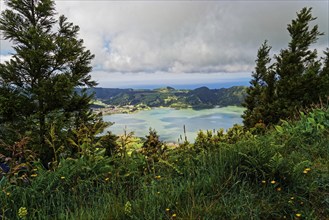 Fascinating view of the crater lake Lagoa Azul with wild flowers in the foreground, Lagoa Azul,