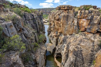 Bridge over a canyon with steep orange-coloured cliffs and the Blyde River, Bourke's Luck Potholes,