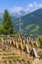 Cemetery with large wooden cross and simple grave crosses, historic village centre, Grimentz, Val