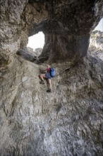 Hiker climbing through the Schindertor, Schinder, Tegernsee mountains in the Mangfall mountains,