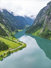 A mirror-like mountain lake nestled in a green, mountainous landscape, Stilluptal, Austria,