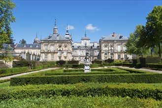 Baroque palace with manicured hedges and sculptures against a clear blue sky, Royal Castle La