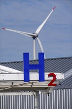 Hydrogen filling station in Antwerp, for cars and lorries, H2 lettering, wind turbine in the