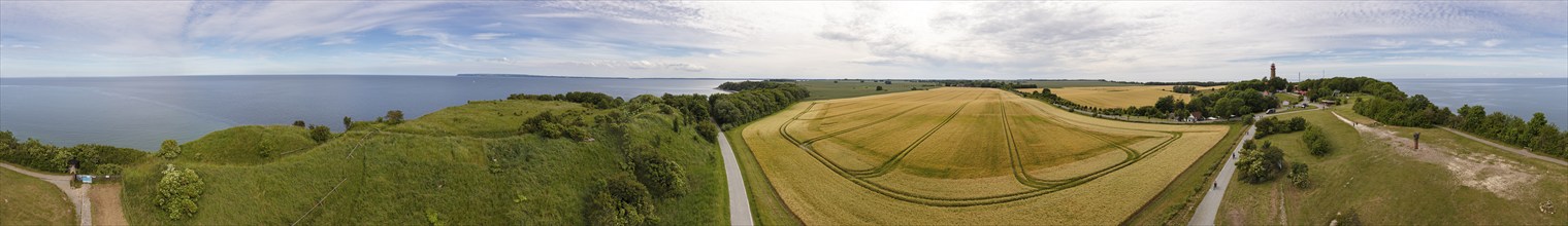 Panorama of a coastal landscape with fields and sea under a slightly cloudy sky, Rügen