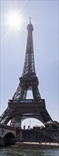 The Eiffel Tower shines under a bright sunlight against a clear blue sky, Paris