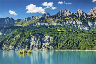 Sunny view over Lake Walen with the small chive island in the turquoise-coloured water at the foot