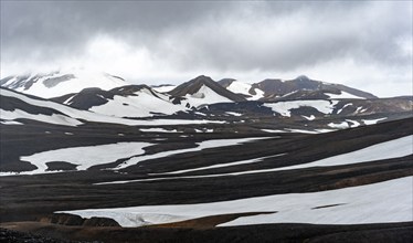 Dramatic volcanic landscape with mountains and snow, at Höskuldsskáli hut in Hrafntinnusker,