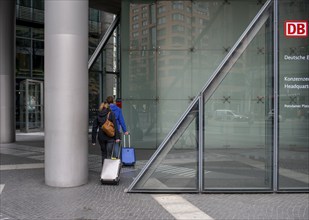 Travellers with luggage at the entrance to the DB Group headquarters at Potsdamer Platz, Berlin,