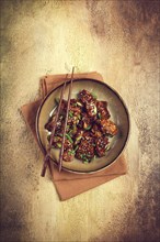 Yakitori chicken kebab, on a plate, with green onions and sesame seeds, top view, no people