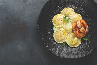 Ravioli with shrimp, in cream sauce, with spices and herbs, top view, no people